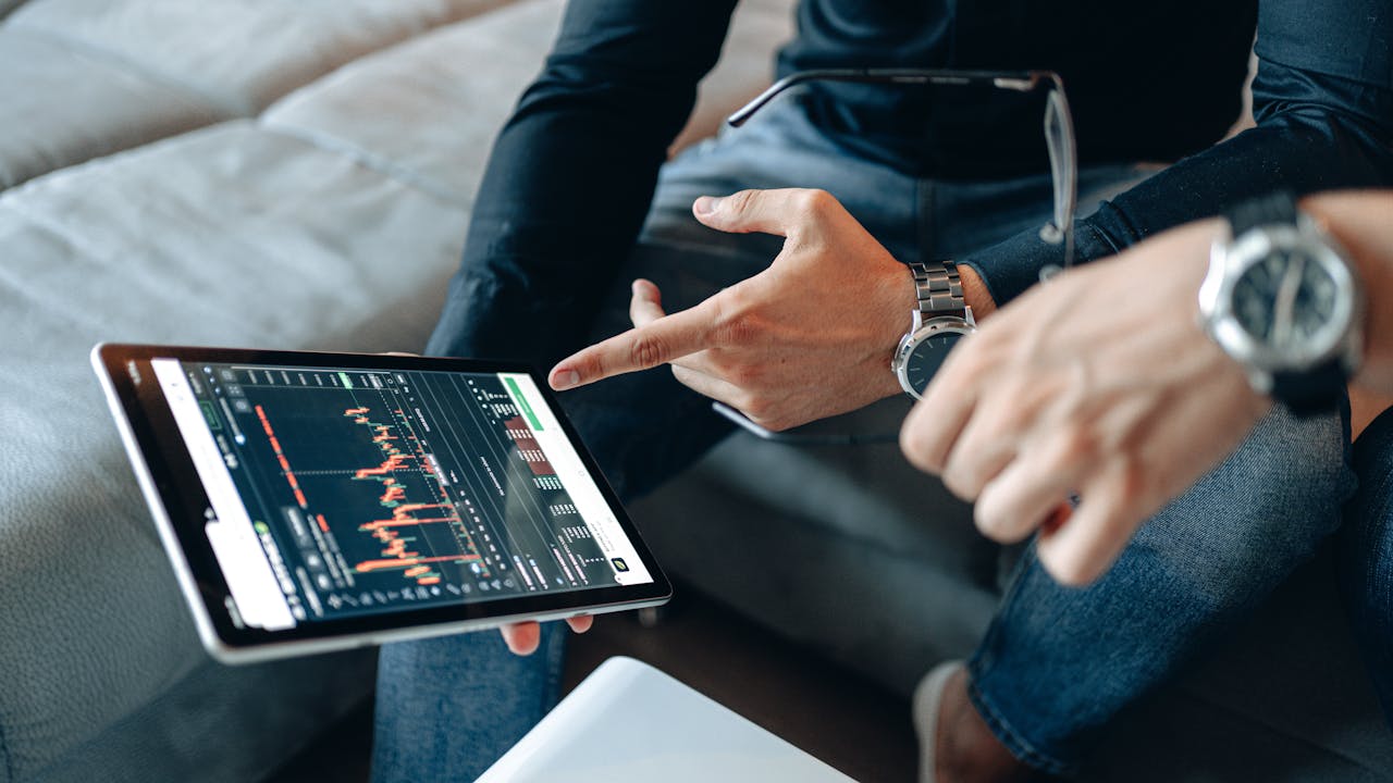 Two people discussing cryptocurrency data on a digital tablet.